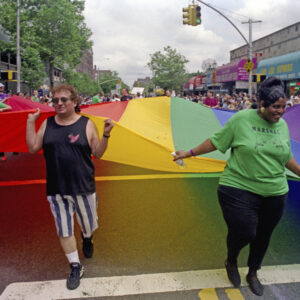 thumbnail of Photo of Queens Pride Parade participants carry the LGBT rainbow flag.