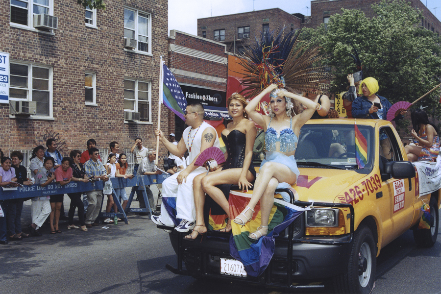 thumbnail of Photo of several people sitting on a car in part of a parade