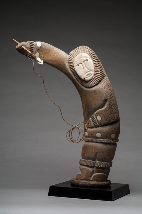 thumbnail of Sculpture made out of whale bone, ivory face, baleen eyes and chin tattoos baleen and ivory inlays, bone base by Tony Weyiouanna Jr. titled Shishmaref Woman Fishing.