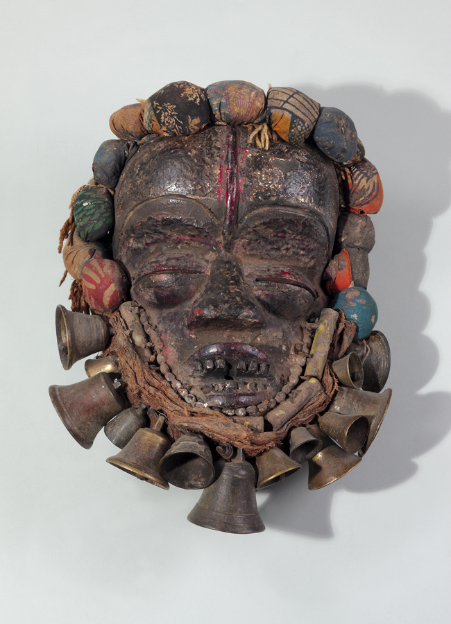 thumbnail of Mask (gela) with Bells from We (Guere), Ivory Coast/Liberia. medium: wood, cloth amulets, brass bells. dimensions: height of 15 inches. date: unknown