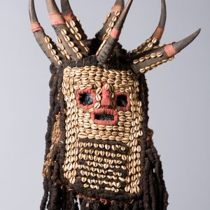 thumbnail of Mask, Ku'Ngang Society from Western Grassfields, Bamileke: Bandjoun. medium: Human hair, animal horns, cowrie shells, textile. date: early 19th century