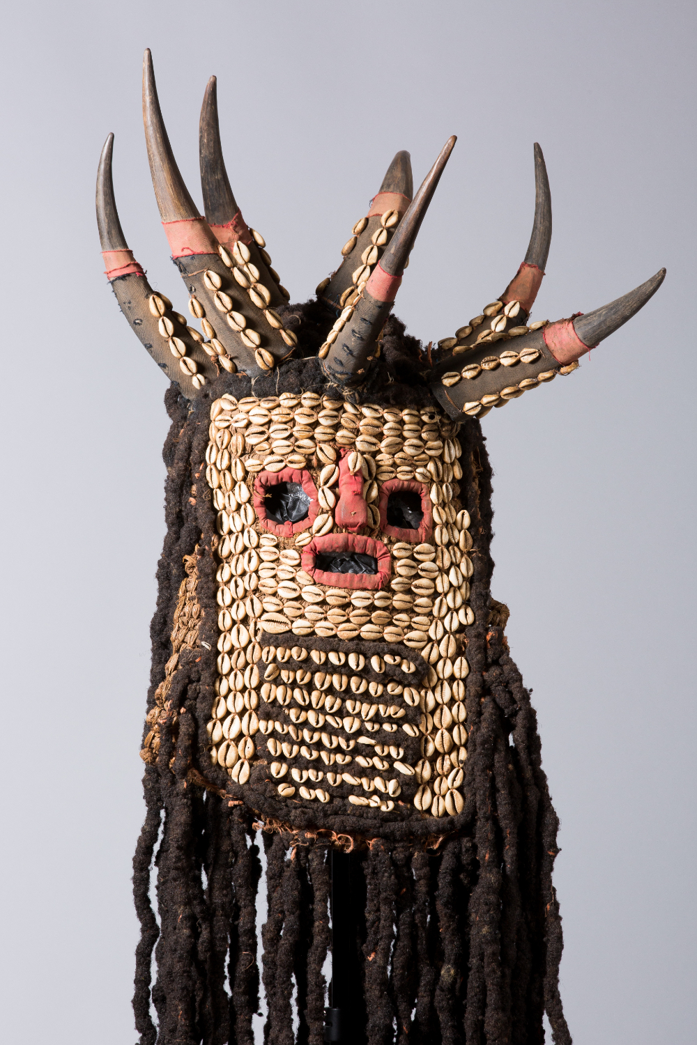 thumbnail of Mask, Ku'Ngang Society from Western Grassfields, Bamileke: Bandjoun. medium: Human hair, animal horns, cowrie shells, textile. date: early 19th century