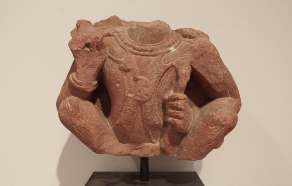thumbnail of Squatting Figure, Surya from Mathura. medium: Red sandstone. date: 2nd century A.D.
