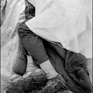 thumbnail of Sleeping in a muddy field by Dan Budnik. medium: silver gelatin print. date: March, 1965. dimensions: 8 x 11.75 inches