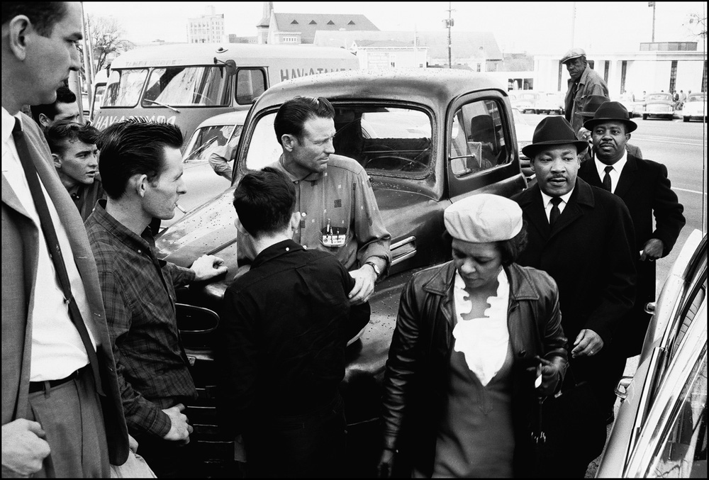 thumbnail of Mrs. Hazel Gregory, Dr. Martin Luther King Jr., Ralph Abernathy passing spectators outside the Dexter Avenue Baptism Church by Dan Budnik. medium: silver gelatin print. date: March, 1965. dimensions: 8.25 x 12 inches