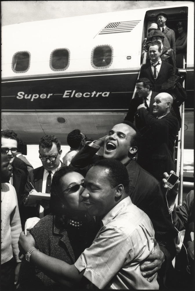 thumbnail of Mrs. King having greeted Harry Belefonte with a kiss, shares one with Dr. King, who playfully pretended jealousy, Montegory by Dan Budnik. medium: silver gelatin print. date: 1965. dimensions: 12.25 x 8.125 inches