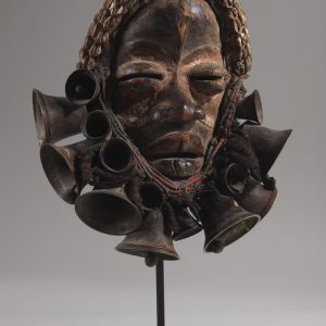 thumbnail of Singer Mask (Ble Gla) from Wè (Ngere), Ivory Coast/Liberia. medium: Wood, brass bells, hair, red beads, cowries. dimensions: unknown. date: unknown.